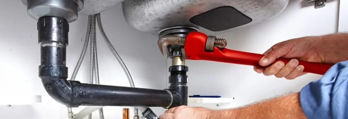 Garbage disposal repair technician tightening the sink drain and disposal connection in Grand Rapids, MI