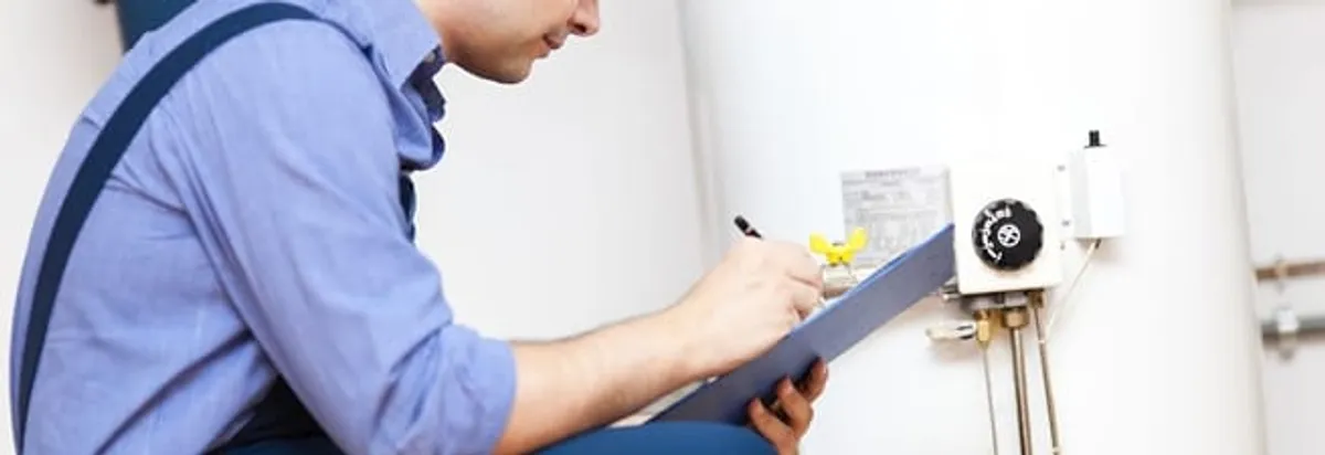 Water heater repair technician inspecting the unit and recording service notes in Grand Rapids, MI